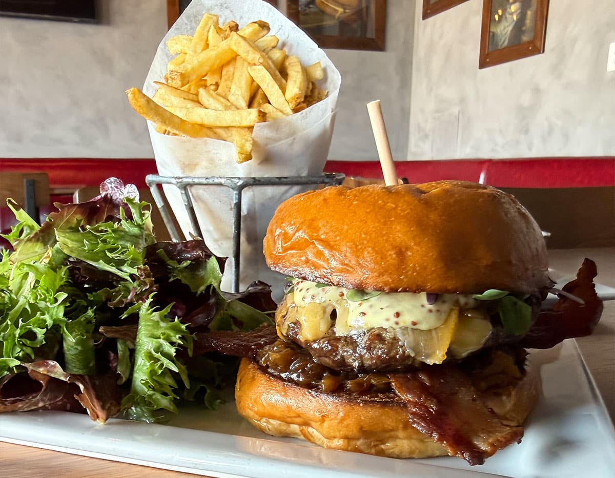 Specialty burger with fries and a side salad